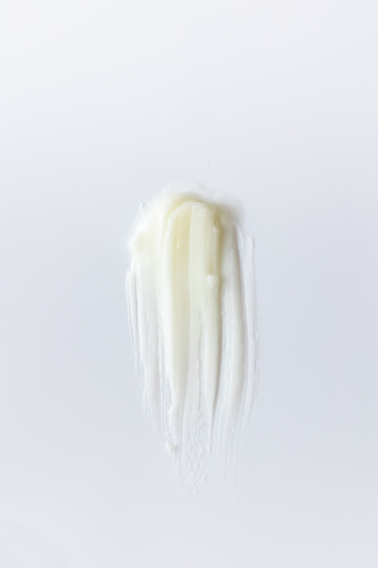 A pale, creamy balm spread across a white surface