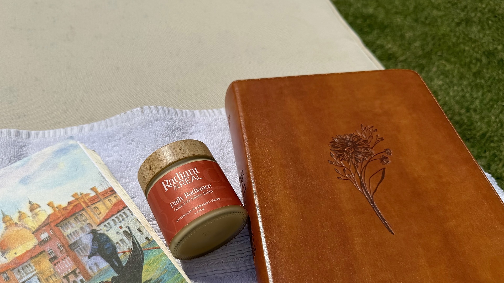 Radiant & Real Daily Radiance balm beside an open Bible and leather journal