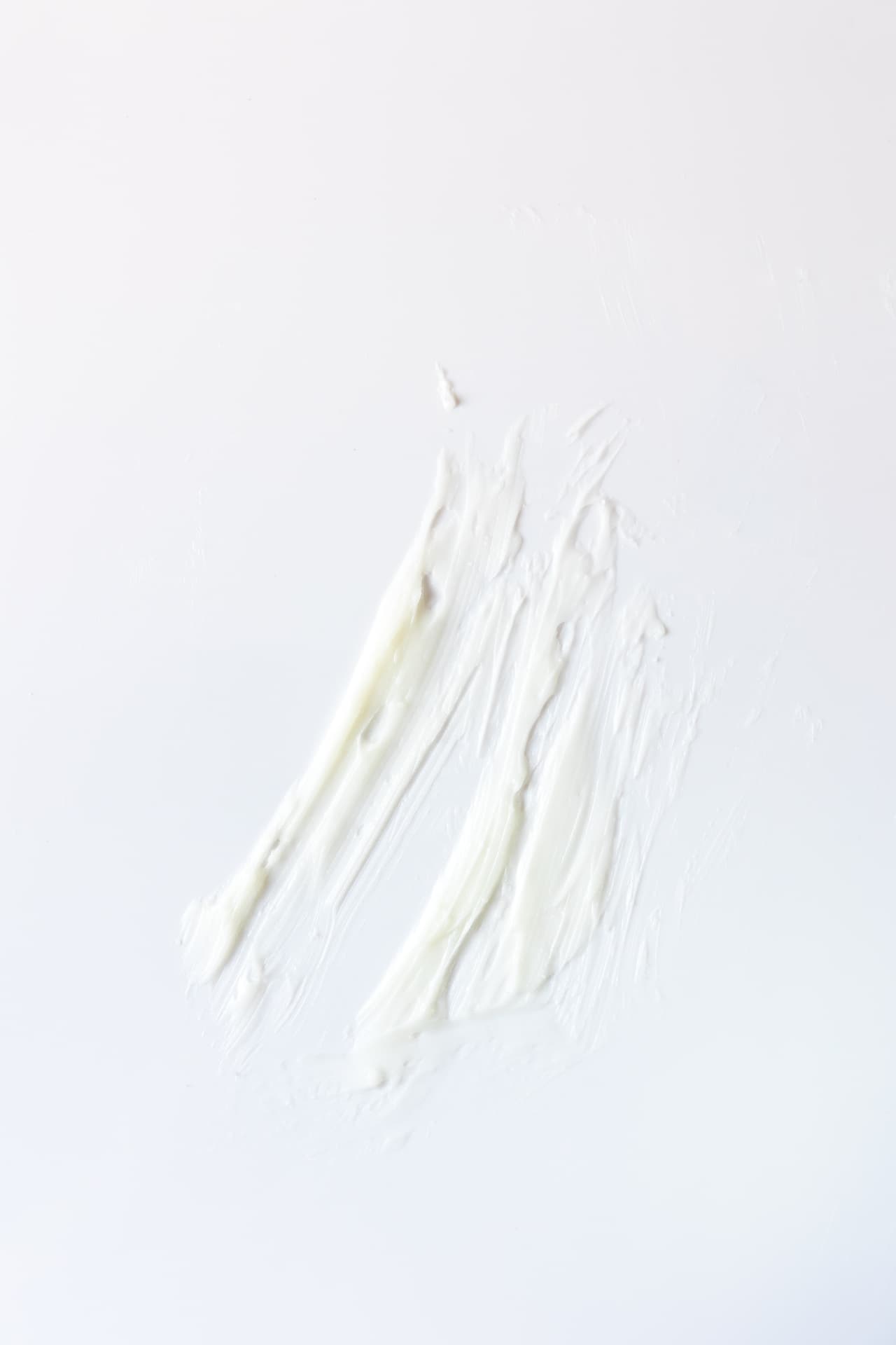 A light-colored balm smear on a white surface, illustrating the formula’s texture