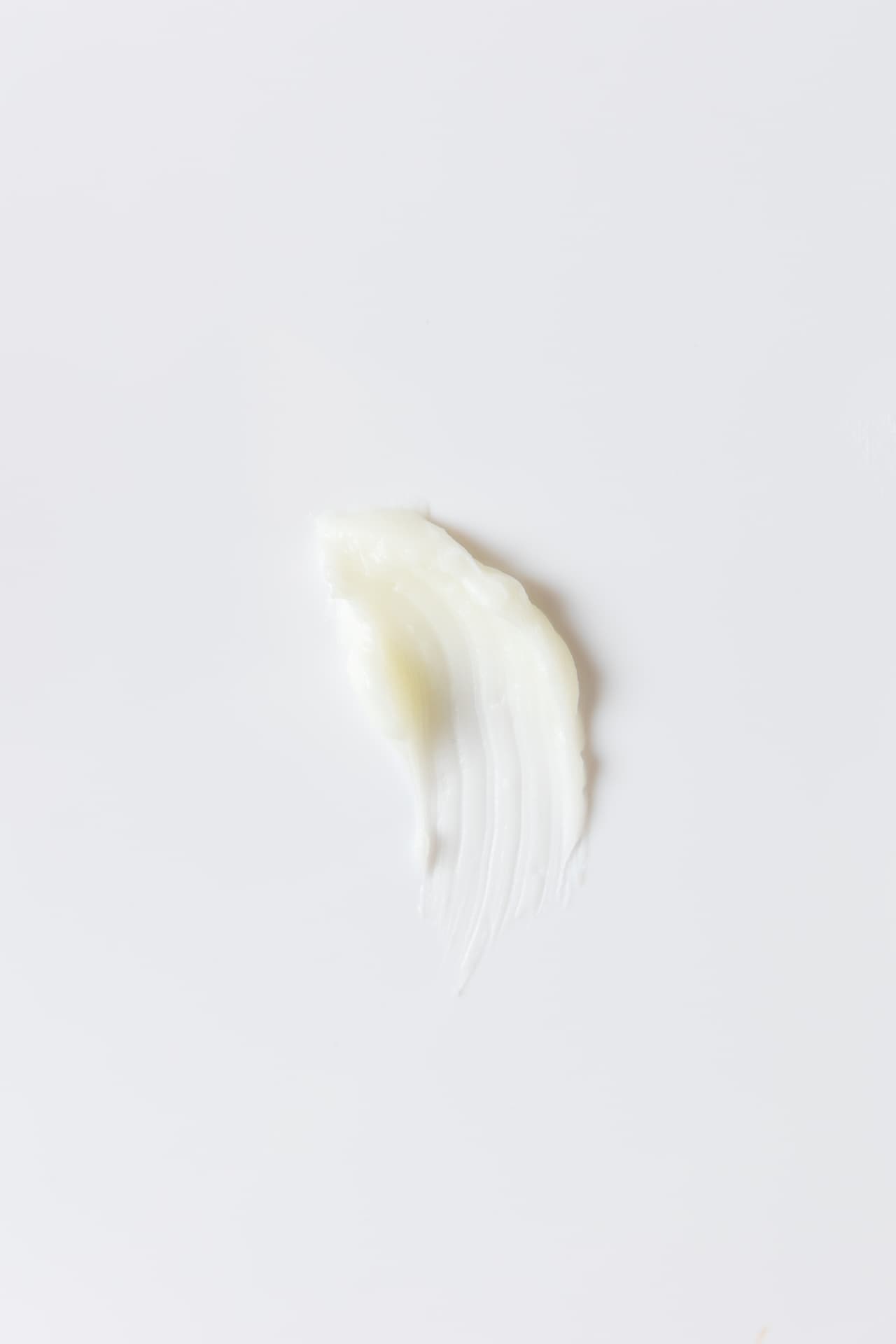 A soft ivory-colored balm texture on a white surface